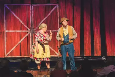 Ma McCoy and Pa Hatfield talking on stage