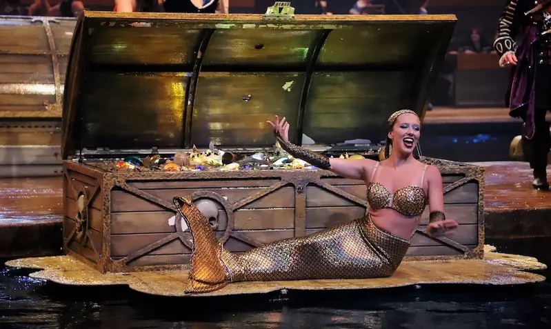 mermaid at Pirates Voyage in front of treasure